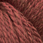 Close-up image of red Cascade Eco and Cascade Eco Plus Wool Yarn fibers intertwined in a textured and slightly fuzzy appearance. The eco yarn, from Cascade Yarns, features a rich, earthy red tone with subtle variations in color.